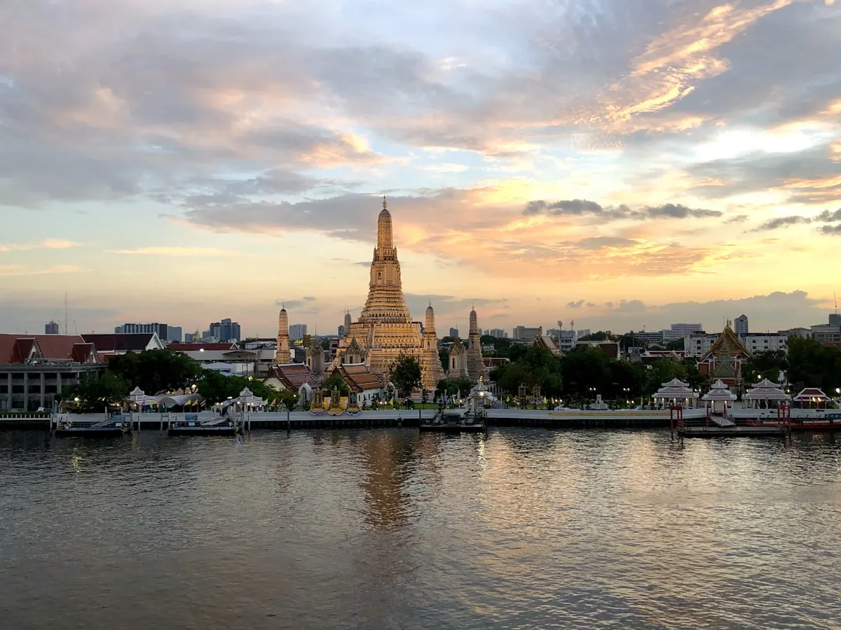 Wat Arun temple at sunset over the Chao Phraya River, Bangkok
